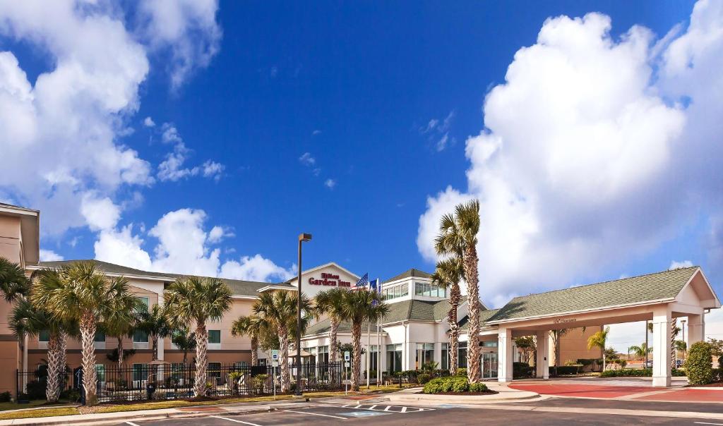 a view of a hotel with palm trees at Hilton Garden Inn Corpus Christi in Corpus Christi