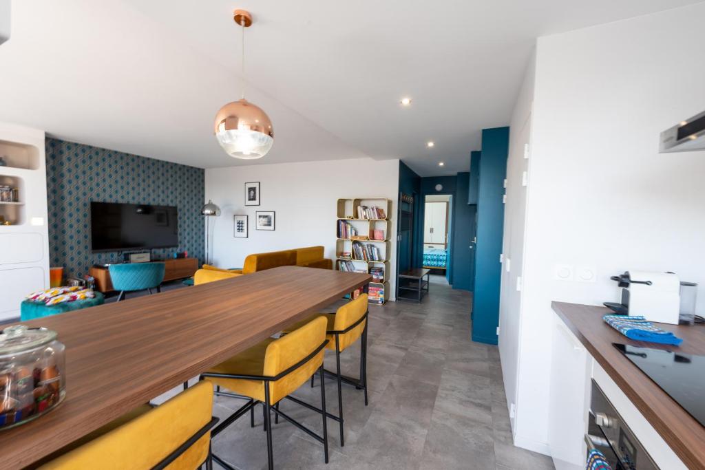 cocina y comedor con mesa larga y sillas amarillas en Happy 70's - Family Place, en Villeurbanne