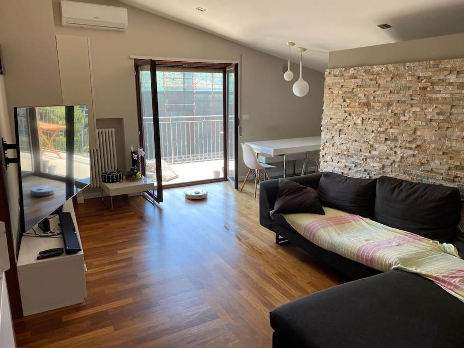 - un salon avec un canapé et un mur en briques dans l'établissement Appartamento incantevole a due passi dal borgo, à Montesilvano