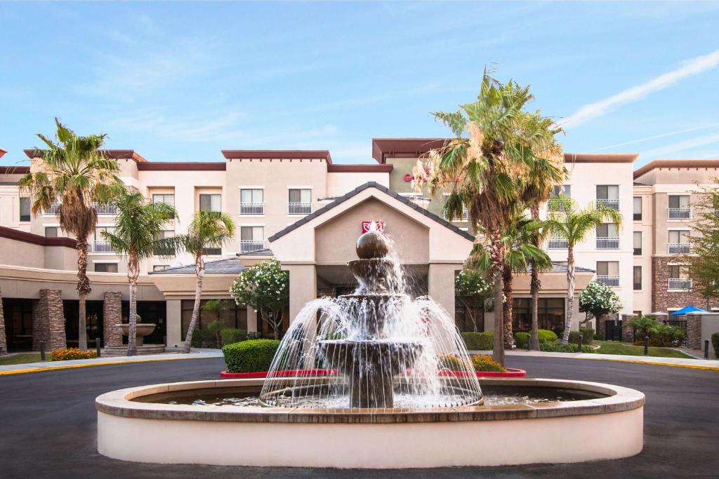una fuente frente a un edificio con palmeras en Hilton Garden Inn Phoenix/Avondale, en Avondale