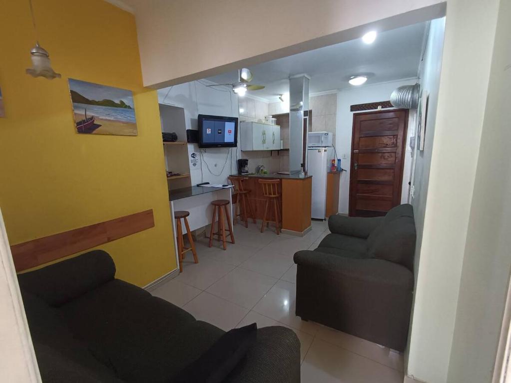 sala de estar con 2 sofás y cocina en Apartamento Meia Cinco, en Santos