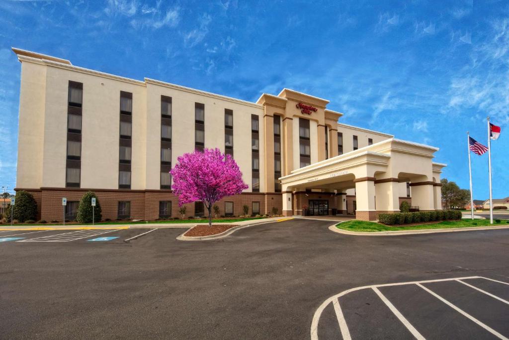 a large building with a pink tree in front of it at Hampton Inn Dunn in Dunn