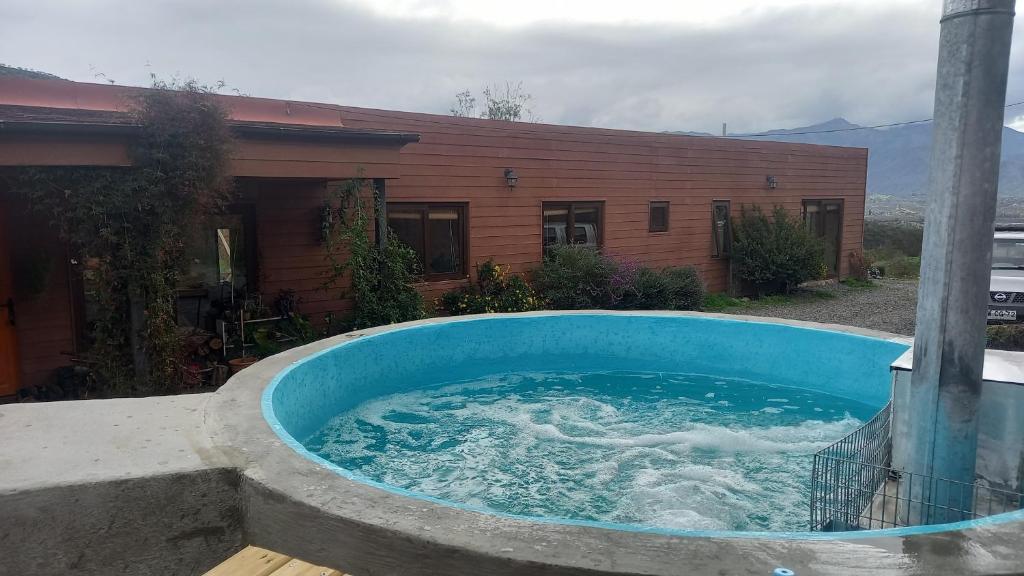 a hot tub in front of a house at Casa con linda vista de montaña y tinaja in Curacaví