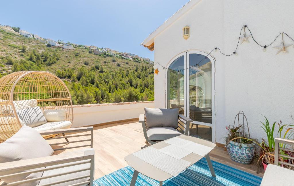 een patio met 2 stoelen en een tafel op een balkon bij Villa Freyer DeLux Benitachell by Nora Nice in Cumbre del Sol