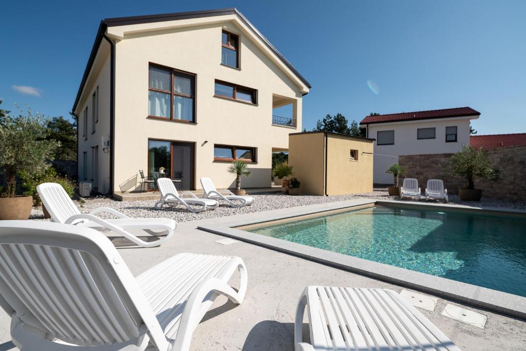 eine Villa mit einem Pool und einem Haus in der Unterkunft Apartments Kras 24 with Pool in Sežana