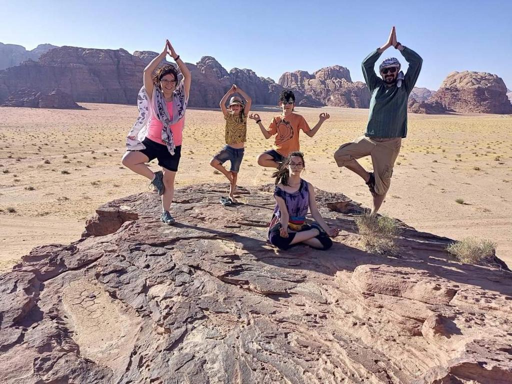 a group of people doing yoga in the desert at Desert Nights Camp in Wadi Rum