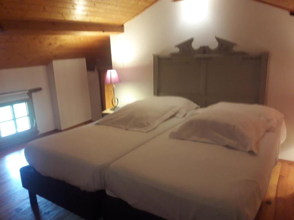 ein Schlafzimmer mit einem großen weißen Bett in einem Zimmer in der Unterkunft Chambre privée dans une maison typique gasconne in Ornézan