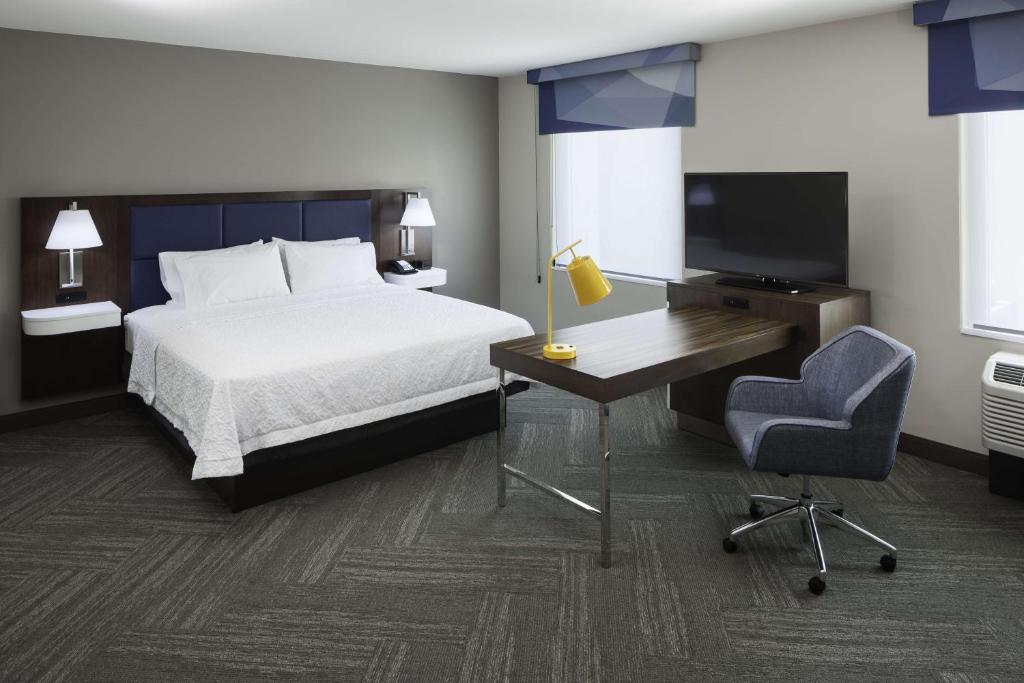フェニックスにあるHampton Inn & Suites Phoenix Downtownのベッドと机とテレビがあるホテルの部屋