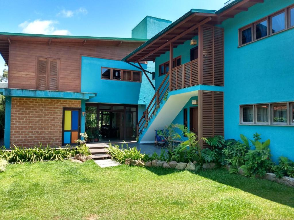 uma casa azul com um quintal em frente em Pousada Vila Guyrá em Florianópolis