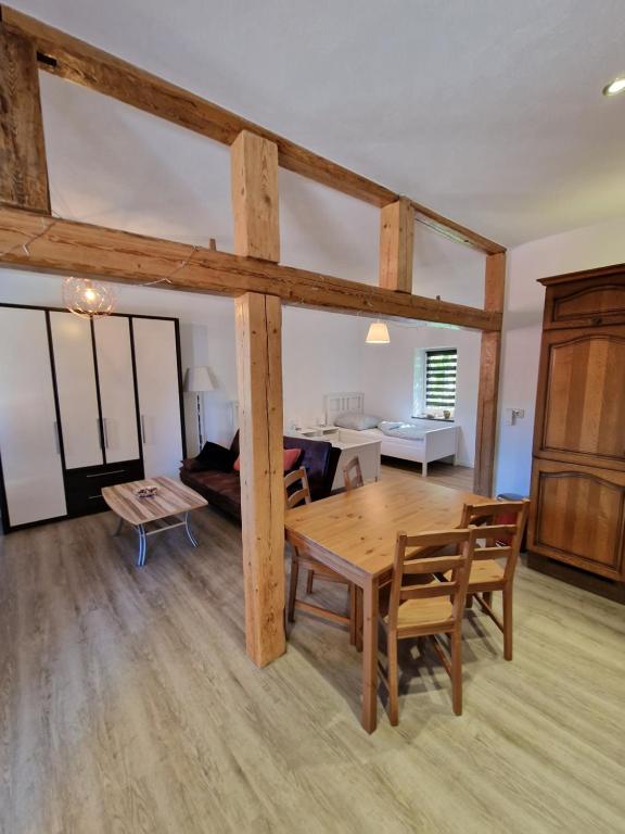 ein Wohnzimmer mit einem Holztisch und einem Sofa in der Unterkunft Apartment auf dem Hof einer historischen Mühle in Holzhausen