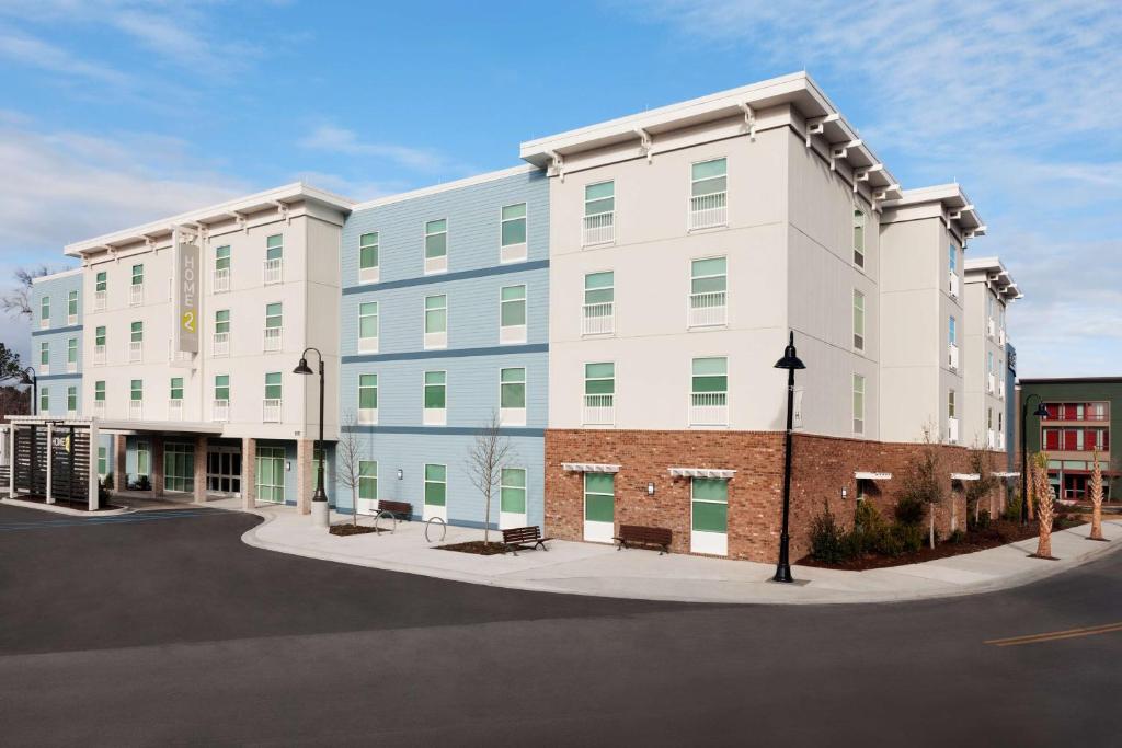 a large white building with green windows on a street at Home2 Suites By Hilton Mt Pleasant Charleston in Charleston