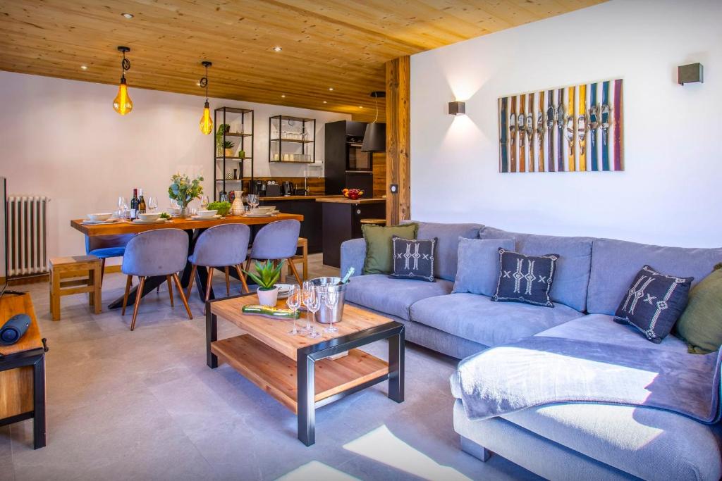 a living room with a blue couch and a table at Loft Monte Clusio - OVO Network in La Clusaz