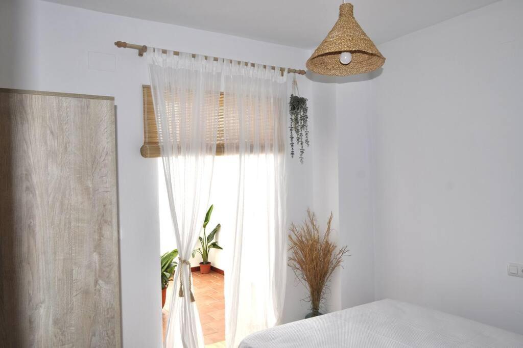 - une chambre avec un lit et une fenêtre dans l'établissement Azahares Apartamento turístico, à El Bosque
