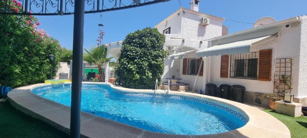 ein Schwimmbad in einem Hof neben einem Haus in der Unterkunft Villamartin Villa Oasis in Alicante