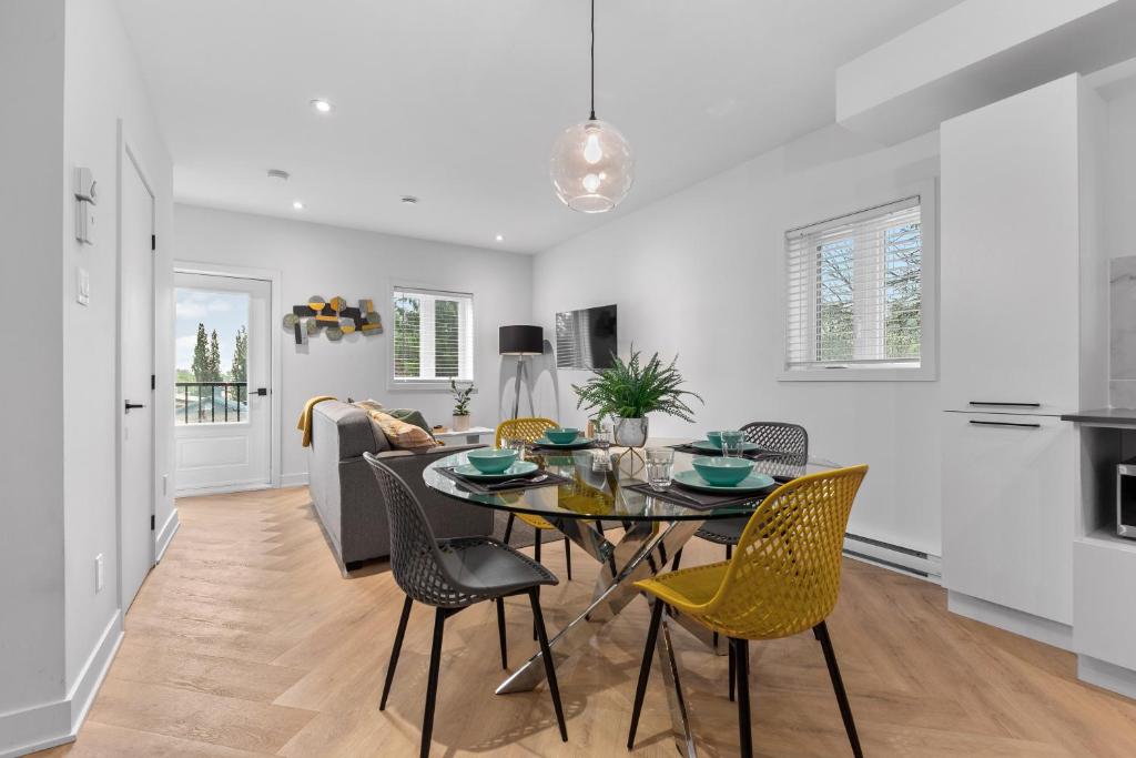 a dining room and living room with a table and chairs at Le Karina - Vieux-Terrebonne in Terrebonne