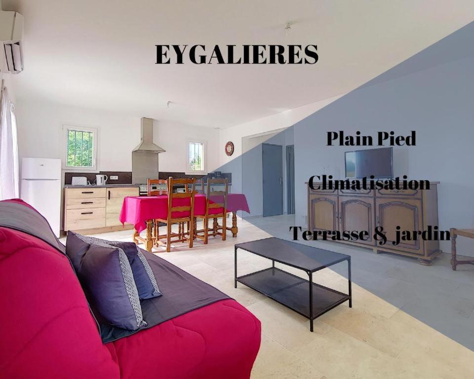 een woonkamer met een rode bank en een keuken bij Location Eygalieres "le Juliette" in Eygalières