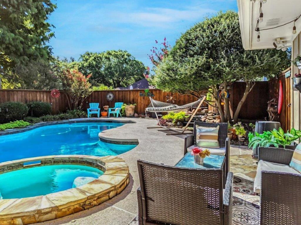 a backyard with a swimming pool with chairs and a fence at Gorgeous Plano Home ~ Private Backyard Pool Oasis in Plano