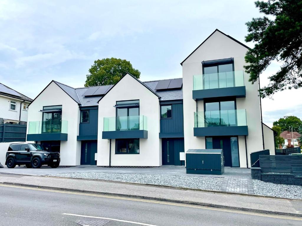 a row of houses on the side of a street at Stunning Brand New House - Sleeps 6 - Free Parking - Great Location - Fast WiFi - Smart TV - Close to Poole & Bournemouth & Sandbanks in Poole