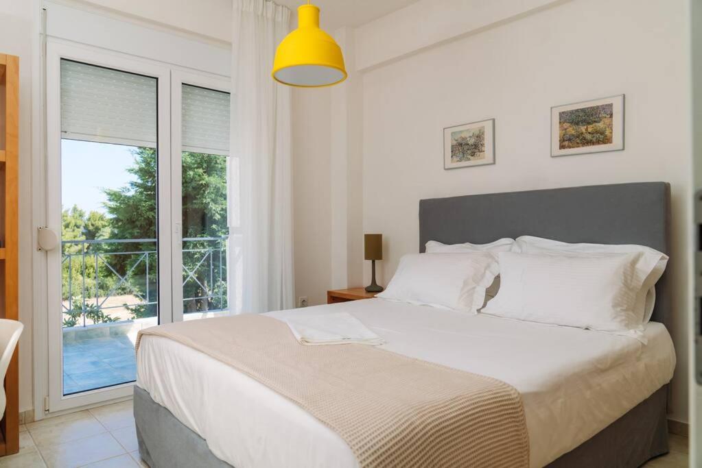 Un dormitorio con una cama grande y una ventana grande. en Villa olion, en Afitos