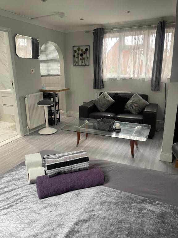 sala de estar con sofá y mesa de cristal en Newly renovated studio in Acton en Londres