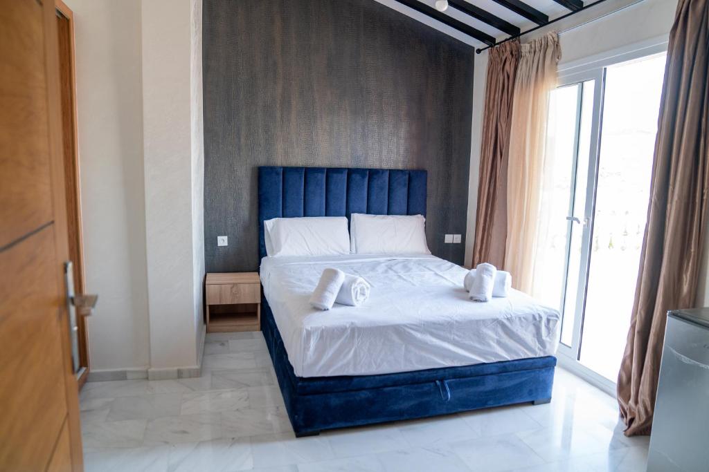 ein Schlafzimmer mit einem blauen Bett und Handtüchern darauf in der Unterkunft CASA DEL TITO in Oulad Akkou