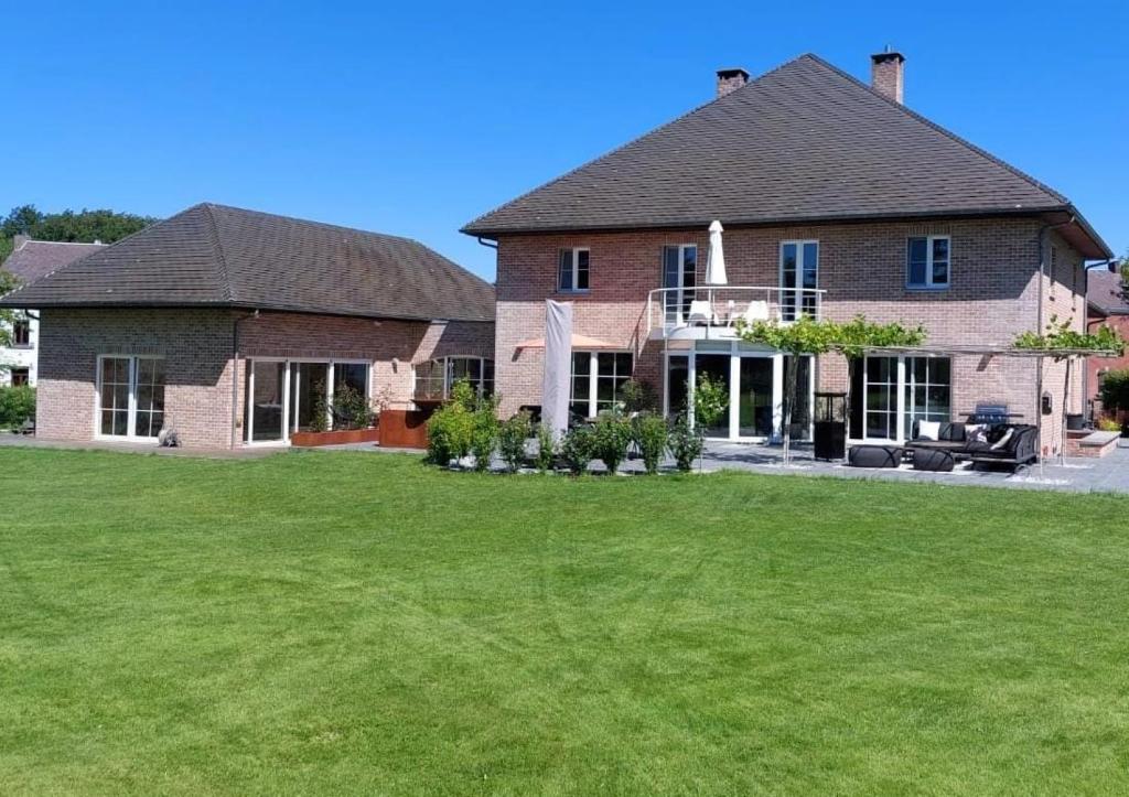 a large brick house with a large yard at Sherlock's Home - Guest House in Namur