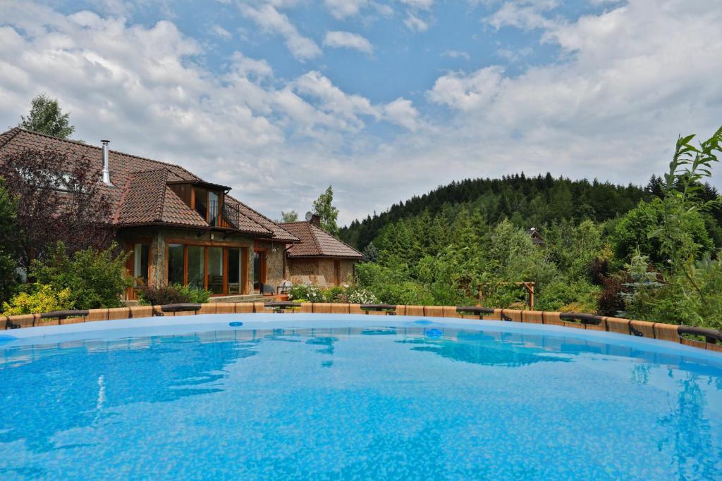 a large blue swimming pool in front of a house at Babie Zacisze in Zawoja