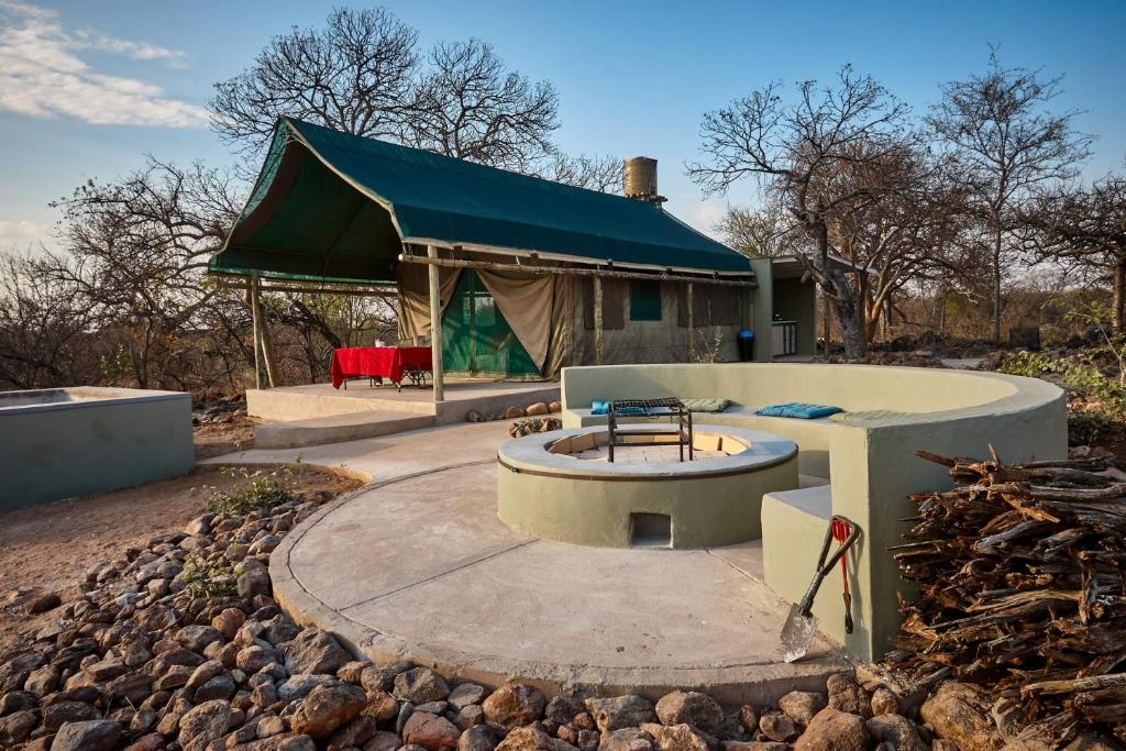 a building with a fire pit in a yard at ZuriCamp - Tent Zahir in Tsumeb