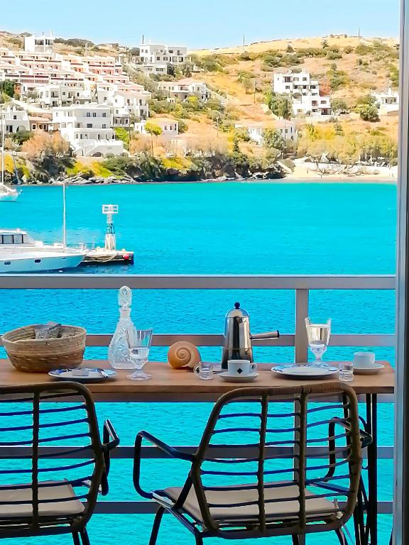 a table with two chairs and a view of the water at Isalos Stay Andros in Batsi
