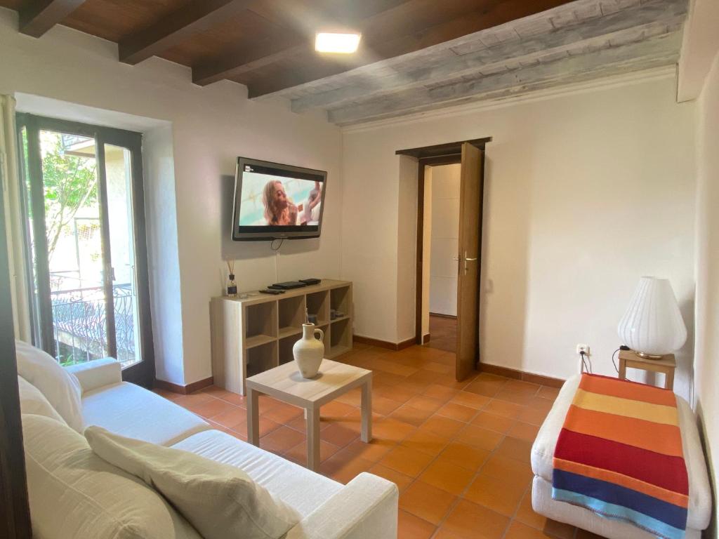 un soggiorno con divano e TV a parete di Casa Bellavista - Serena a Lugano
