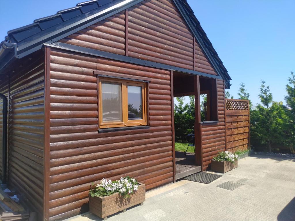 a house with a wooden exterior with a window at Domek letniskowy in Władysławowo