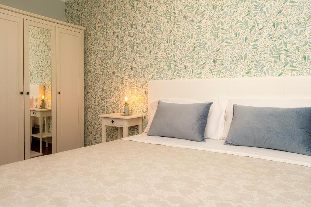 1 dormitorio con 1 cama grande con almohadas azules en El balcón de Barraña en Boiro