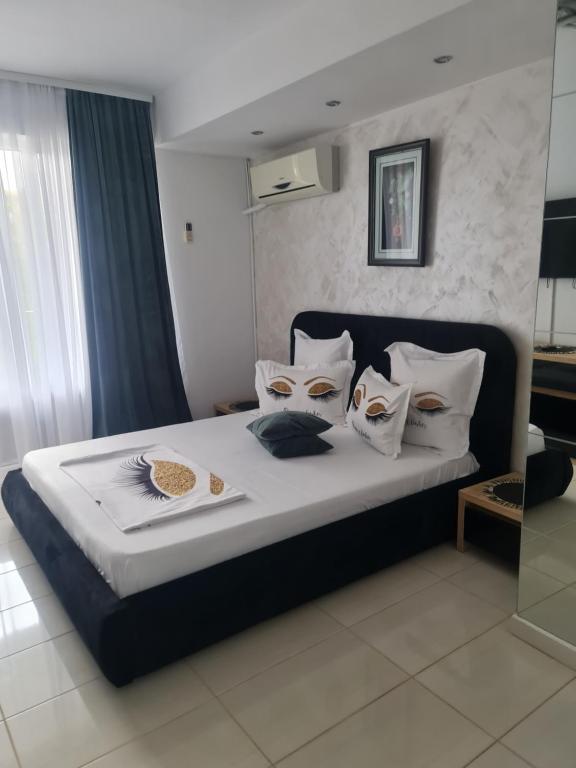 a bedroom with a bed with white sheets and pillows at Casa Day&Amy in Eforie Sud