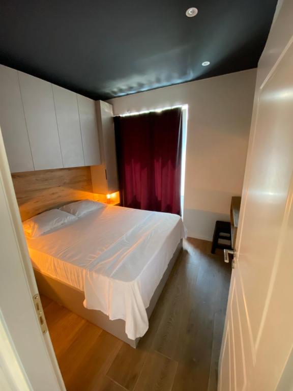 - une chambre avec un lit et un rideau rouge dans l'établissement EQ Tirana Apartments, à Tirana