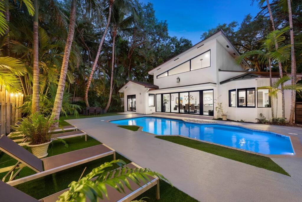 an exterior view of a house with a swimming pool at Coconut Grove Villa with heated Pool sleeps 12 in Miami