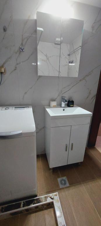 a white bathroom with a sink and a mirror at Nina Apartment in Drama