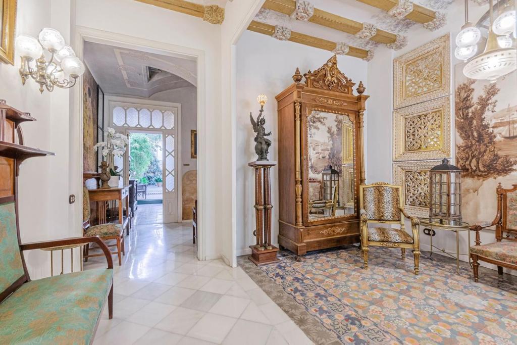 una sala de estar con un gran reloj de abuelo y sillas en El Petit Palauet, en Canet de Mar