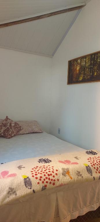 Un dormitorio con una cama con una manta de colores. en Kitnet em Monte alto arraial do cabo en Arraial do Cabo