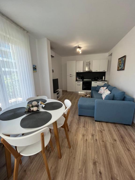 uma sala de estar com um sofá azul e uma mesa em Azzurro Premium Apartment on Bulevard Bogoridi em Burgas