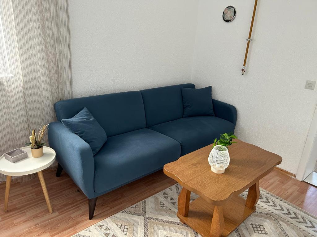 a blue couch in a living room with a table at The heart of Sarajevo in Sarajevo