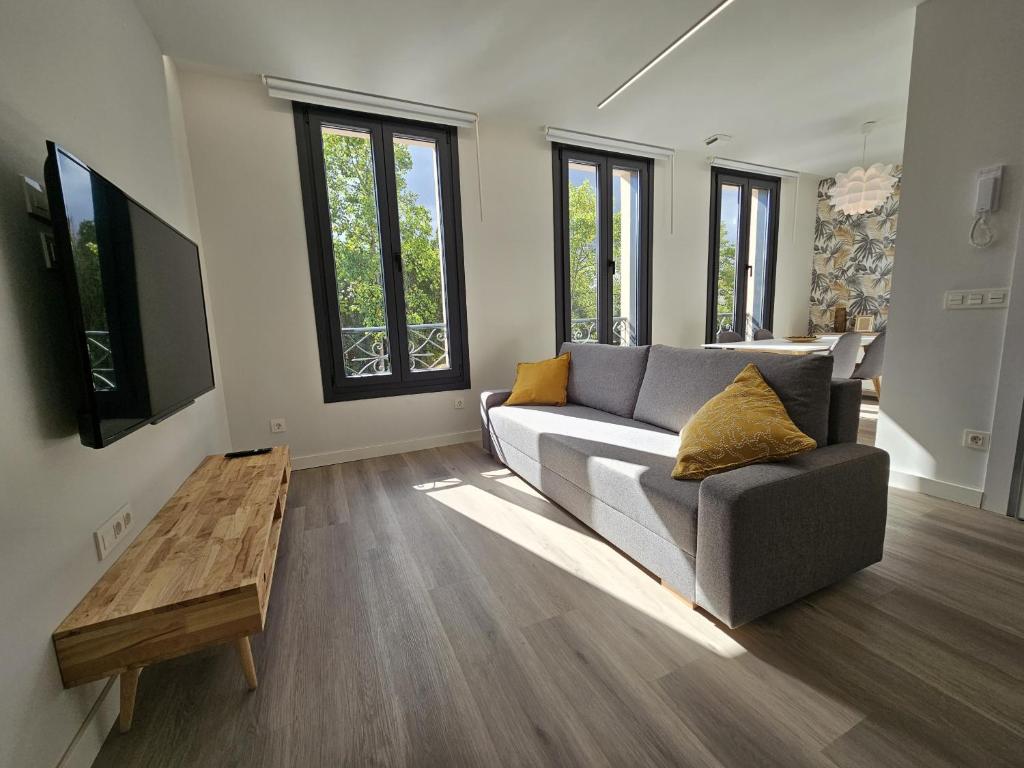 een woonkamer met een bank en een tafel bij 1A105 Precioso apartamento en zona exclusiva in Gijón