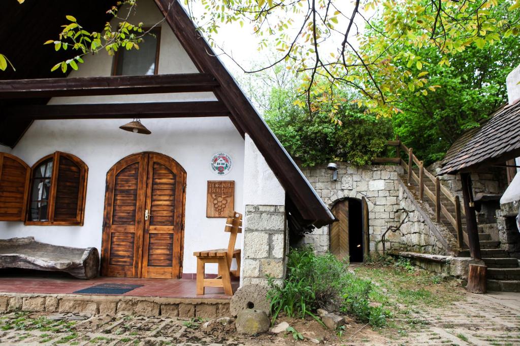 a house with a wooden door and a chair at Myrtus Pince és Vendégház in Tarcal