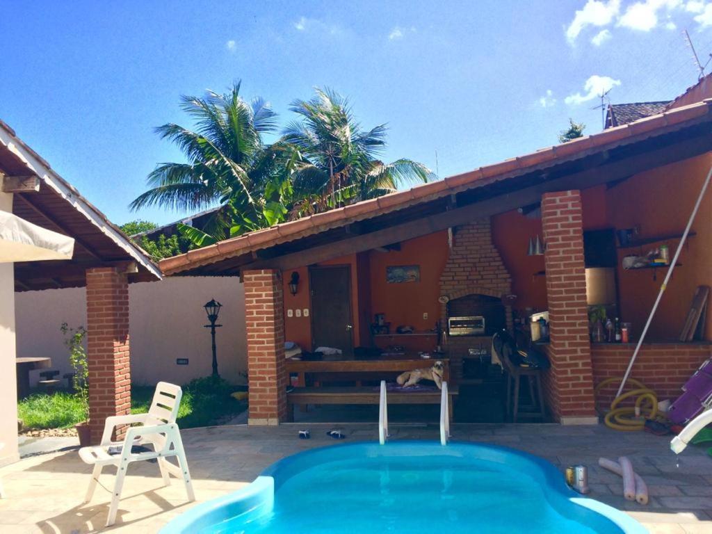 a house with a swimming pool in front of it at Guaru Surf Hostel in Guarujá