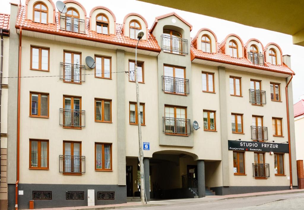 ウォムジャにあるPiękna Apartments Greyの赤い屋根の白い大きな建物