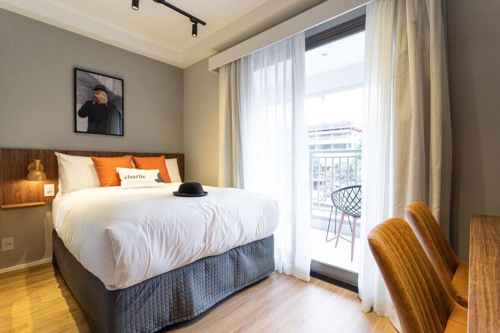 a bedroom with a bed and a large window at Charlie Hotel Atmosfera Paulista in Sao Paulo