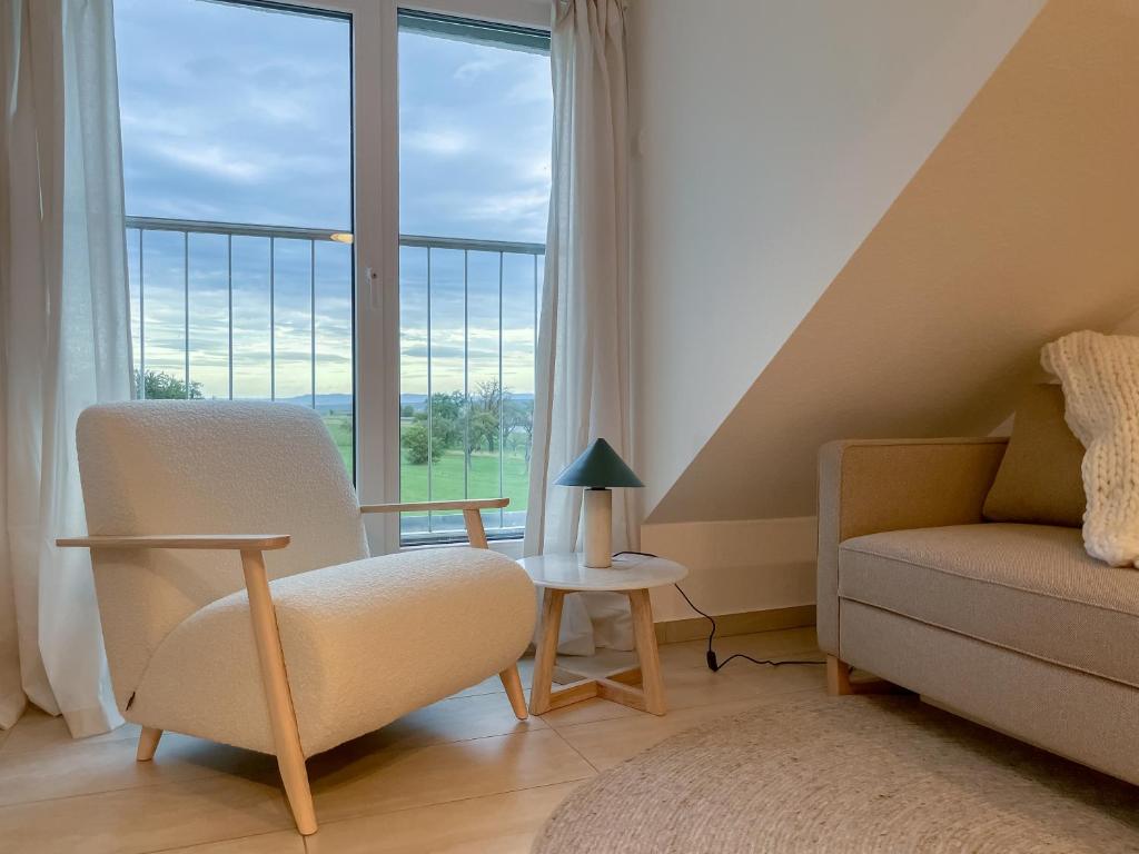 a living room with a couch and a chair and a window at Deluxe Apartments - Stuttgart Flughafen & Messe - Parkplatz in Stuttgart