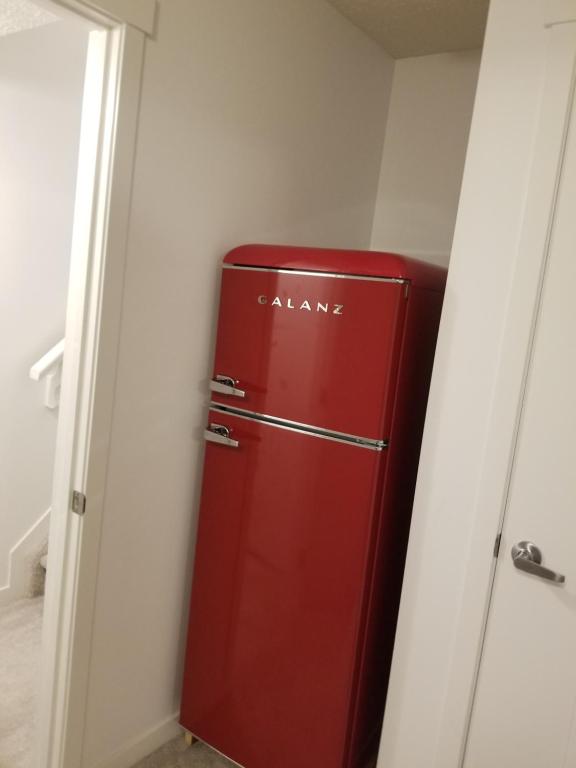 a red refrigerator in a corner of a room at Newcastle. A Place you can call home in Edmonton