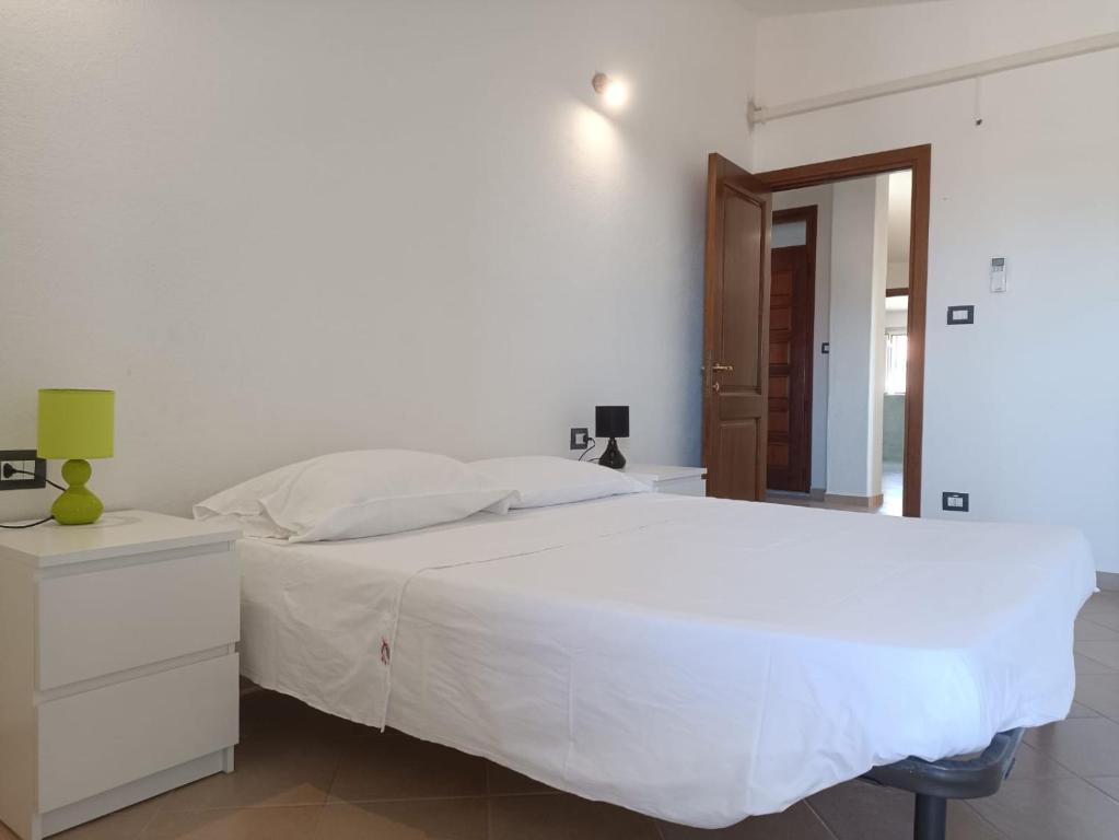 a white bedroom with a white bed and a mirror at Residenza Maria Antonia - Appartamento Francesco in Orosei