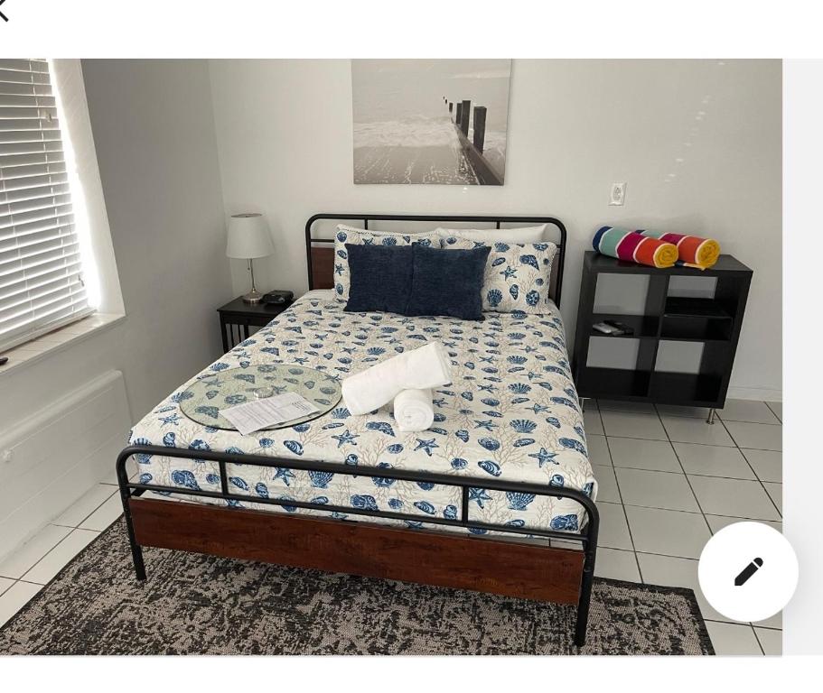 um quarto com uma cama com um edredão azul e branco em Little Paris by the ocean self check in em Fort Lauderdale