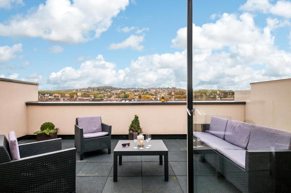 a patio with two chairs and a table on a balcony at Solar Sanctuary- Skyline Balcony, City Centre, Three Floors, King Beds, Netflix and more! in Bath